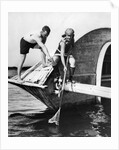 1920s man and woman in bathing suits crabbing off old abandoned wooden boat by Anonymous