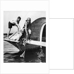1920s man and woman in bathing suits crabbing off old abandoned wooden boat by Anonymous