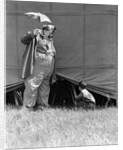 1930s man clown catching little boy peeking under circus big top tent by Anonymous