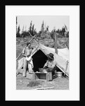 1930s smiling talking couple working by rustic western campsite tent man in cowboy hat smoking pipe washing skillet woman drying dishes by Anonymous