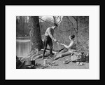 1920s 1930s man & woman camping by lake having picnic woman sitting man standing serving food to woman east creek swamp by Anonymous
