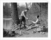 1920s 1930s man & woman camping by lake having picnic woman sitting man standing serving food to woman east creek swamp by Anonymous