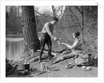 1920s 1930s man & woman camping by lake having picnic woman sitting man standing serving food to woman east creek swamp by Anonymous