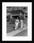 1930s couple walking out of house down sidewalk carrying picnic baskets & thermos jug by Anonymous