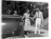 1930s family of four getting into convertible automobile with picnic basket and thermos jug by Anonymous