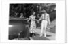 1930s family of four getting into convertible automobile with picnic basket and thermos jug by Anonymous