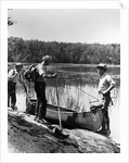 1930s three fishermen standing beside canoe holding fishing gear net backpack lake of the woods ontario by Anonymous