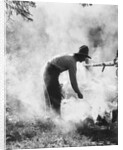 1920s 1930s man cowboy cook bending over campfire by Anonymous