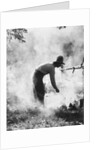 1920s 1930s man cowboy cook bending over campfire by Anonymous