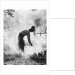 1920s 1930s man cowboy cook bending over campfire by Anonymous