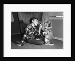 1950s boy in plaid shirt shaking finger at dog sitting up on rear legs by Anonymous