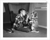 1950s boy in plaid shirt shaking finger at dog sitting up on rear legs by Anonymous