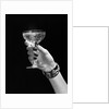 1930s 1940s 1950s woman hand ornate metal bracelet holding up new year toast glass of champagne against black background by Anonymous