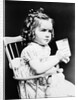 1930s child girl sitting in high chair holding glass of milk serious look bow in hair baloney curls by Anonymous