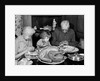 1950s 1960s little girl look at turkey sitting between grandmother grandfather saying grace at table by Anonymous