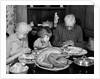 1950s 1960s little girl look at turkey sitting between grandmother grandfather saying grace at table by Anonymous