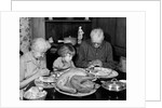 1950s 1960s little girl look at turkey sitting between grandmother grandfather saying grace at table by Anonymous