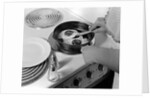 1940s 1950s woman hands frying eggs in iron skillet on electric stove salt and pepper shakers by Anonymous
