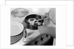 1940s 1950s woman hands frying eggs in iron skillet on electric stove salt and pepper shakers by Anonymous