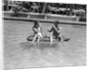 1930s 1940s couple drinking while floating in a pool on a rubber raft at florida resort by Anonymous