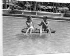 1930s 1940s couple drinking while floating in a pool on a rubber raft at florida resort by Anonymous
