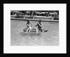 1930s 1940s couple drinking while floating in a pool on a rubber raft at florida resort by Anonymous