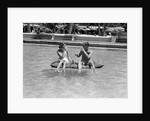 1930s 1940s couple drinking while floating in a pool on a rubber raft at florida resort by Anonymous