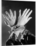 1930s woman's hands tied together by rope overhead view by Anonymous
