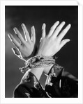 1930s woman's hands tied together by rope overhead view by Anonymous