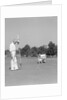 1930s 1940s elderly men on golf green one holding flag the other kneels lining up his putt by Anonymous