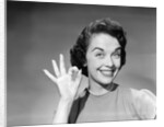 1950s woman smiling wearing pearl necklace looking at camera making okay gesture with hand by Anonymous