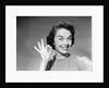 1950s woman smiling wearing pearl necklace looking at camera making okay gesture with hand by Anonymous