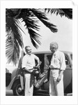 1930s 2 elderly men standing by car carrying golf bag palm tree frond in corner by Anonymous