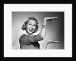 1950s 1960s happy smiling blond woman gesturing with hands showing size of something looking at camera by Anonymous