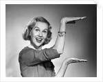 1950s 1960s happy smiling blond woman gesturing with hands showing size of something looking at camera by Anonymous