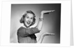 1950s 1960s happy smiling blond woman gesturing with hands showing size of something looking at camera by Anonymous