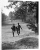 1930s couple man woman each carrying a golf bag walking down the fairway of the golf course by Anonymous