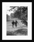 1930s couple man woman each carrying a golf bag walking down the fairway of the golf course by Anonymous