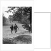 1930s couple man woman each carrying a golf bag walking down the fairway of the golf course by Anonymous