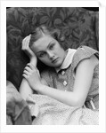 1930s woman moping looking sad or depressed or with a headache leaning her head on her hand looking at camera by Anonymous