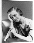 1930s 1940s woman sitting in chair worried sad expression one hand up to her forehead by Anonymous