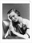 1930s 1940s woman sitting in chair worried sad expression one hand up to her forehead by Anonymous