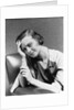 1930s 1940s woman sitting in chair worried sad expression one hand up to her forehead by Anonymous