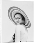 1930s woman wearing striped halter top and very wide brim straw hat looking at camera over shoulder by Anonymous