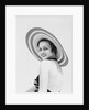1930s woman wearing striped halter top and very wide brim straw hat looking at camera over shoulder by Anonymous