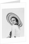 1930s woman wearing striped halter top and very wide brim straw hat looking at camera over shoulder by Anonymous