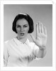 1960s woman looking at camera holding up hand palm forward commanding stop by Anonymous
