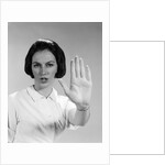 1960s woman looking at camera holding up hand palm forward commanding stop by Anonymous