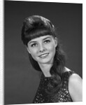 1960s portrait of smiling young woman in sequin dress looking at camera by Anonymous