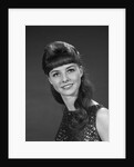 1960s portrait of smiling young woman in sequin dress looking at camera by Anonymous